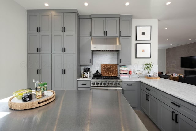 1600 S Milam St, Amarillo, TX 79102 - kitchen with gray cabinets, wall chimney range hood, backsplash, recessed lighting, and high end stainless steel range