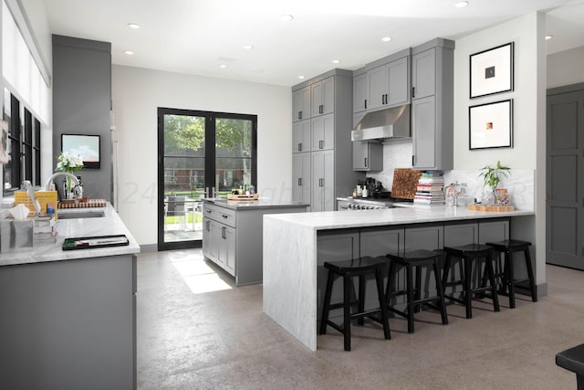1600 S Milam St, Amarillo, TX 79102 - kitchen with a sink, gray cabinets, under cabinet range hood, a peninsula, and a center island