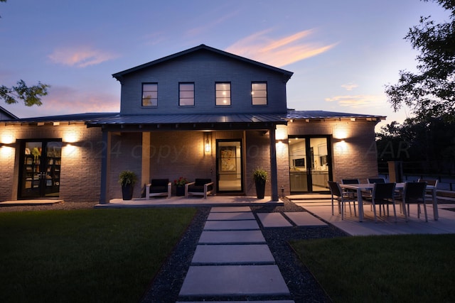 1600 S Milam St, Amarillo, TX 79102 - rear view of house with brick siding, a standing seam roof, a yard, and a patio area