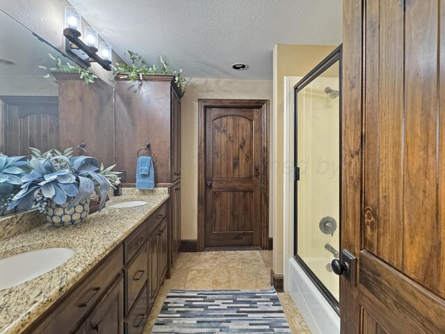 38 Merion Pl, Amarillo, TX 79124 - full bathroom with a textured ceiling, double vanity, tile patterned flooring, and enclosed tub / shower combo