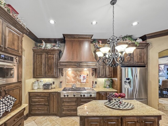 38 Merion Pl, Amarillo, TX 79124 - kitchen featuring stainless steel appliances, custom exhaust hood, ornamental molding, decorative backsplash, and a chandelier