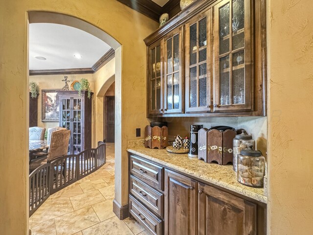 38 Merion Pl, Amarillo, TX 79124 - bar area featuring arched walkways, ornamental molding, a textured wall, and light tile patterned flooring