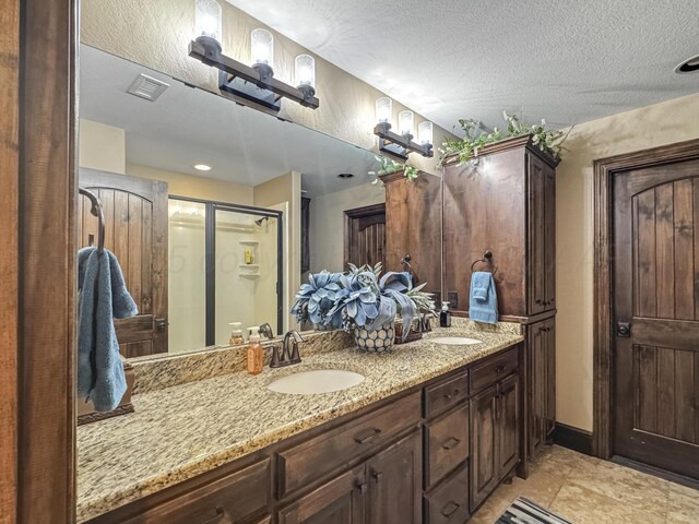38 Merion Pl, Amarillo, TX 79124 - bathroom featuring double vanity, a shower stall, and a textured ceiling