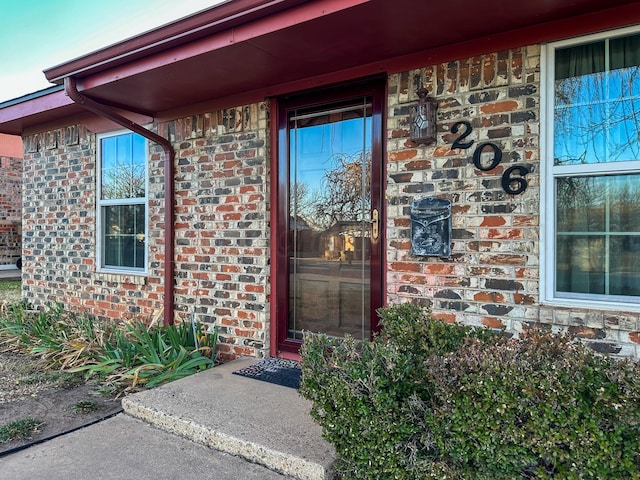 doorway to property with brick siding