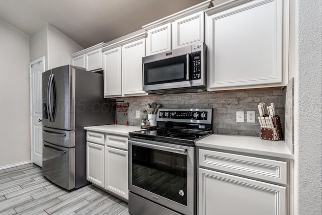 606 Elgin St, Amarillo, TX 79118 - kitchen featuring appliances with stainless steel finishes, decorative backsplash, light countertops, and white cabinetry