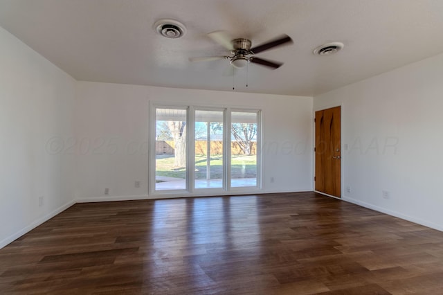 empty room featuring a ceiling fan, visible vents, and wood finished floors