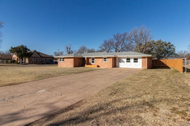 single story home featuring brick siding, an attached garage, a front yard, fence, and driveway