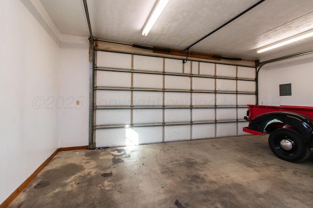 garage with electric panel and baseboards