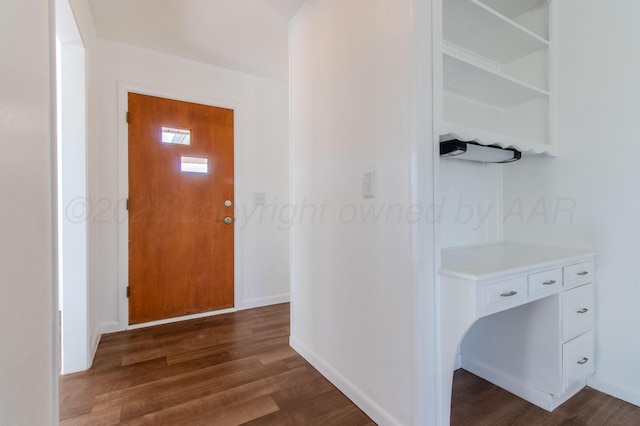 hallway featuring dark wood-style floors and baseboards