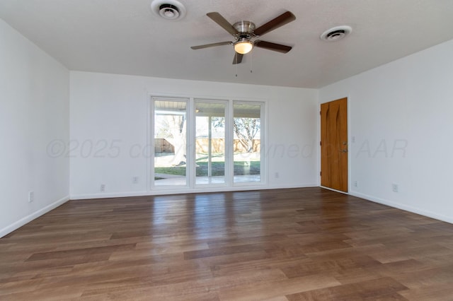 empty room with visible vents, baseboards, and wood finished floors