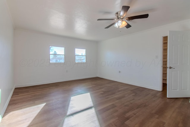 empty room with crown molding, ceiling fan, wood finished floors, and baseboards