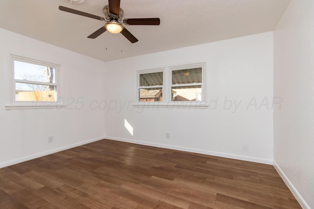 unfurnished room featuring dark wood-type flooring, ceiling fan, and baseboards