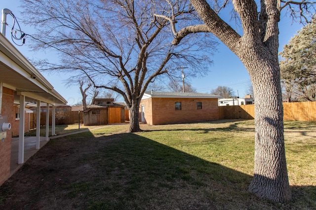 view of yard with a fenced backyard, a patio, and an outdoor structure