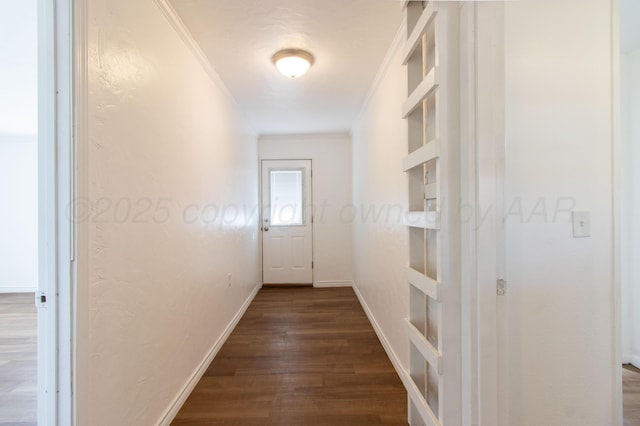 corridor with baseboards, ornamental molding, and dark wood-type flooring