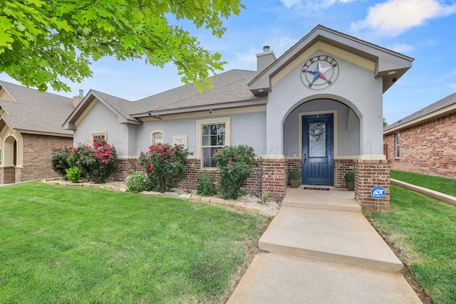 7404 Southbend Dr, Amarillo, TX 79119 - view of front of house featuring brick siding, a front lawn, a chimney, and stucco siding