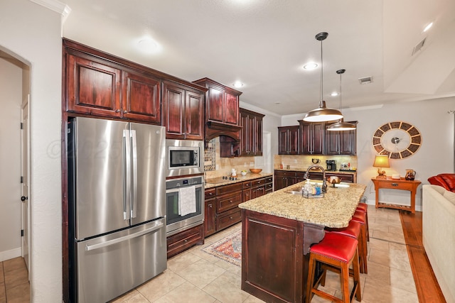 7404 Southbend Dr, Amarillo, TX 79119 - kitchen with appliances with stainless steel finishes, backsplash, light stone countertops, pendant lighting, and a center island with sink