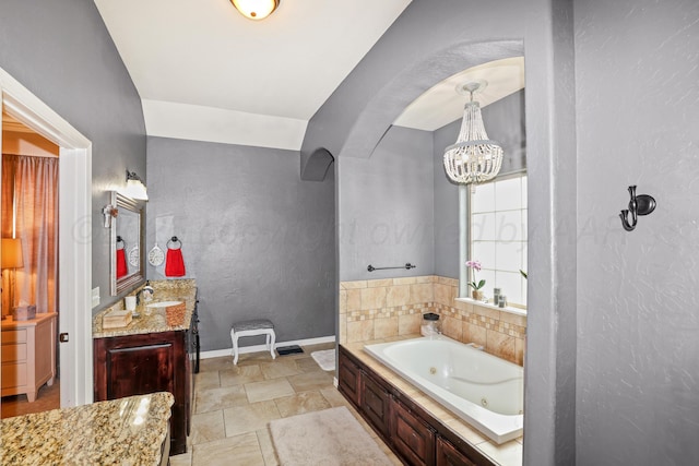 7404 Southbend Dr, Amarillo, TX 79119 - full bathroom with a textured wall, a tub with jets, vanity, and a chandelier