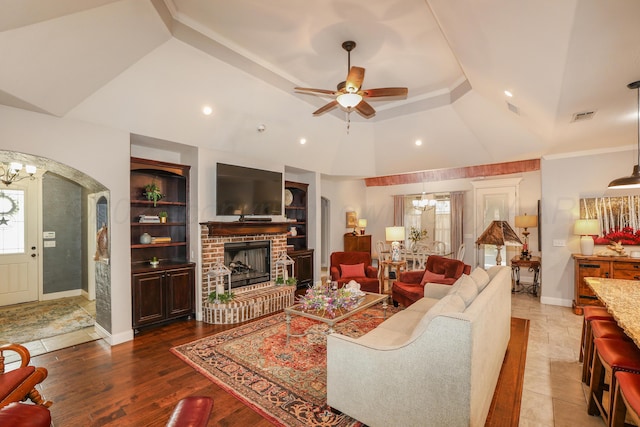 7404 Southbend Dr, Amarillo, TX 79119 - living area featuring a ceiling fan, a brick fireplace, a chandelier, built in features, and arched walkways