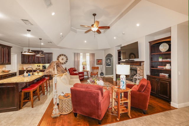 7404 Southbend Dr, Amarillo, TX 79119 - living area with a raised ceiling, a brick fireplace, a ceiling fan, recessed lighting, and light wood-style flooring