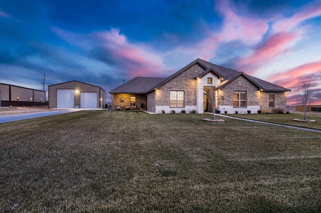 view of front of house featuring a lawn, a garage, and an outdoor structure