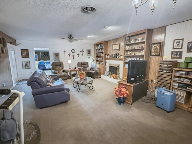 living room featuring carpet flooring, a textured ceiling, and ceiling fan