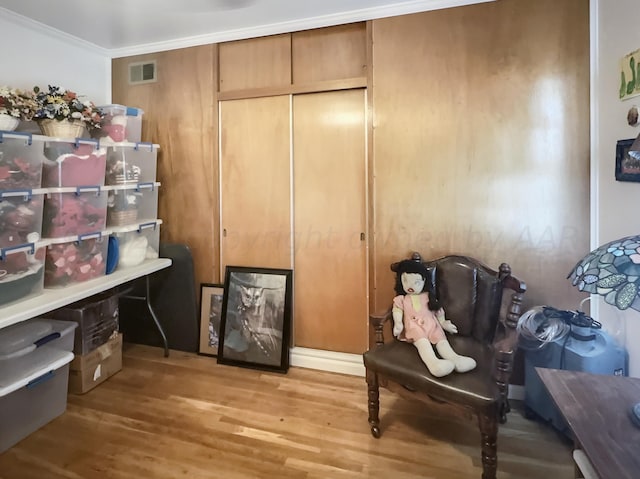 living area with ornamental molding and light wood-type flooring