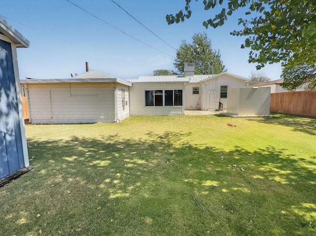 rear view of property featuring a yard