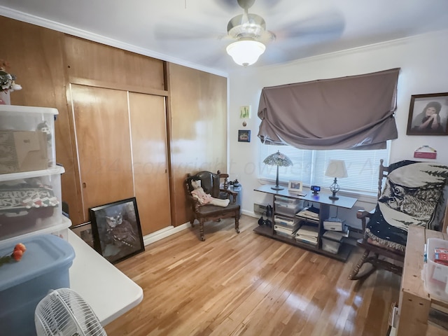 interior space featuring ceiling fan, light wood-type flooring, and ornamental molding