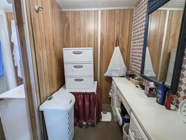 bathroom featuring wood walls and washer / clothes dryer