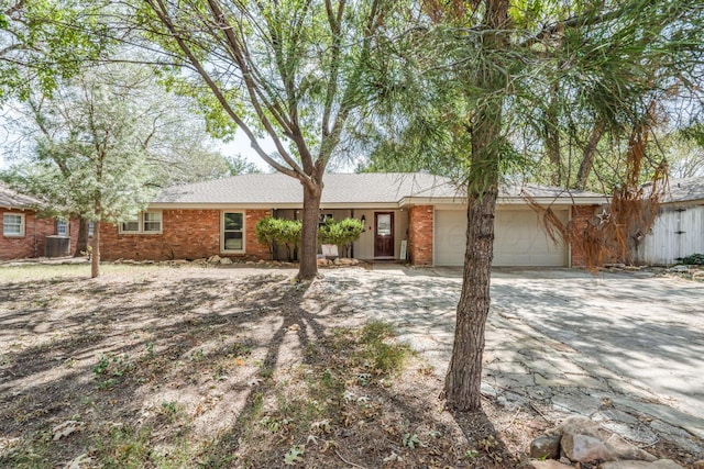 ranch-style house with a garage and central AC unit