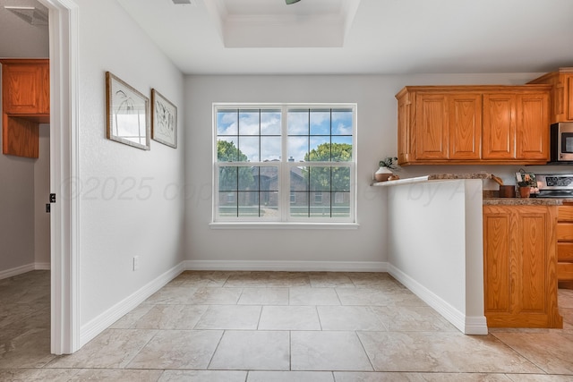 6100 Mckay Ct, Amarillo, TX 79118 - kitchen with appliances with stainless steel finishes, a tray ceiling, and brown cabinetry