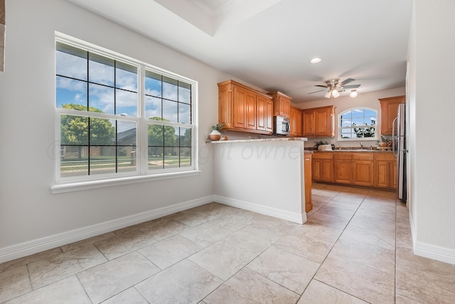 6100 Mckay Ct, Amarillo, TX 79118 - kitchen featuring stainless steel appliances, a ceiling fan, brown cabinetry, and light countertops