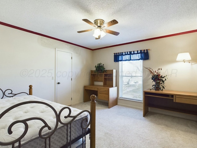 carpeted bedroom featuring ornamental molding, ceiling fan, and a textured ceiling