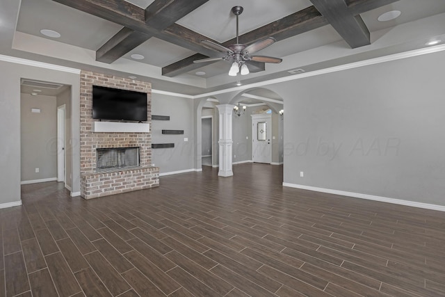 unfurnished living room featuring coffered ceiling, dark hardwood / wood-style floors, ceiling fan, a fireplace, and beam ceiling