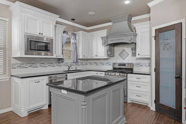 kitchen featuring premium range hood, sink, white cabinets, and stainless steel appliances