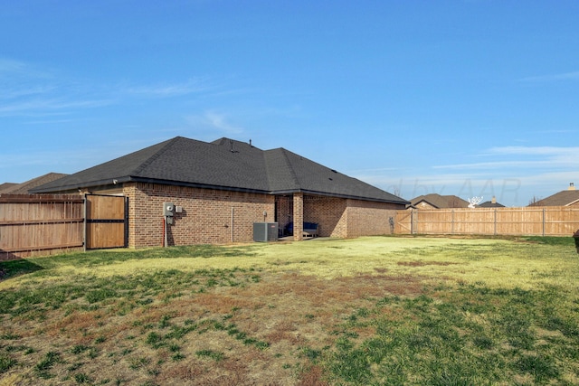 back of property with a lawn and cooling unit