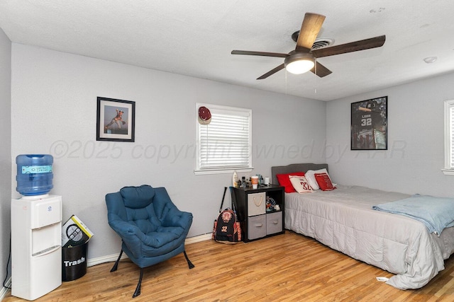 bedroom featuring baseboards, a ceiling fan, and wood finished floors
