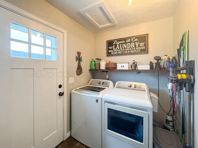 clothes washing area with laundry area, a textured ceiling, and washing machine and dryer