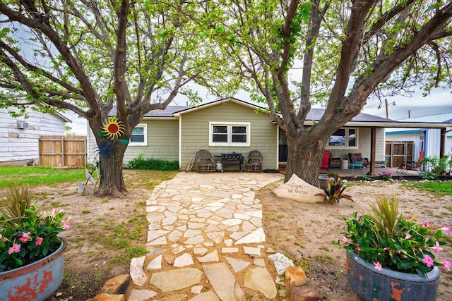rear view of house with fence and a patio