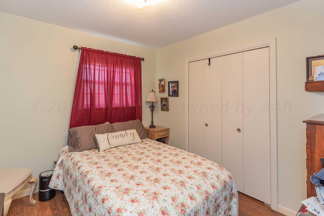 bedroom with a textured ceiling, hardwood / wood-style flooring, and a closet