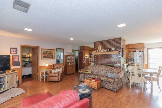 living room featuring hardwood / wood-style floors, a fireplace, and a textured ceiling