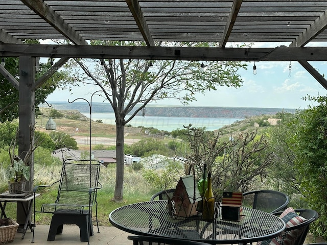 view of patio / terrace with a water view and a pergola