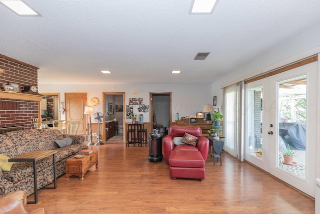 living room featuring light hardwood / wood-style floors and a textured ceiling