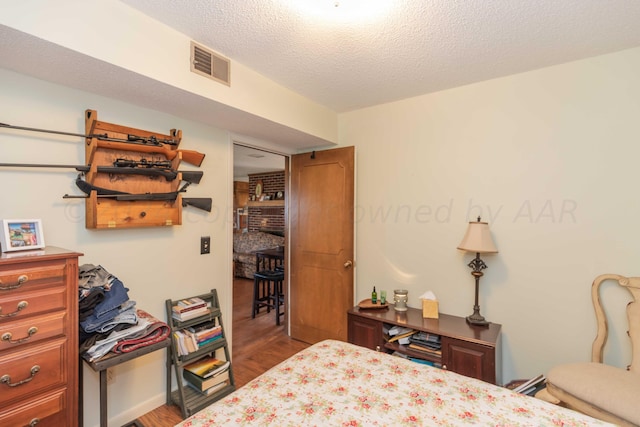 bedroom with hardwood / wood-style floors and a textured ceiling