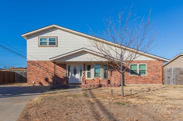 view of front of property featuring brick siding and fence