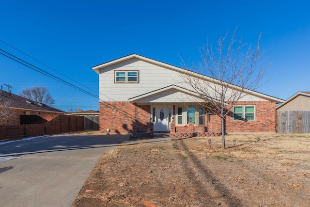 view of front facade featuring fence and brick siding