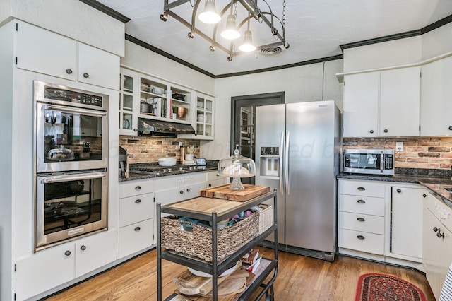 501 Sunset Ter, Amarillo, TX 79106 - kitchen featuring appliances with stainless steel finishes, a chandelier, backsplash, light wood-style floors, and ornamental molding