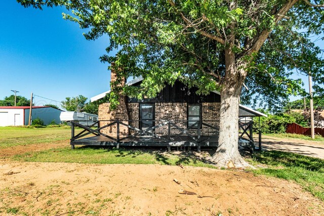 102 Bonanza Dr, Fritch, TX 79036 - back of house featuring a wooden deck, brick siding, and a yard