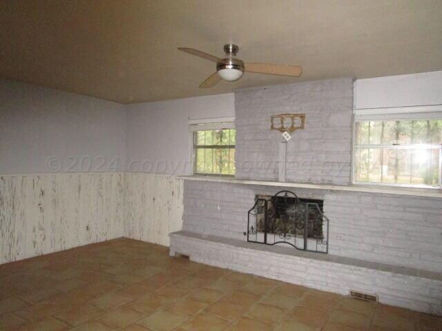 unfurnished living room with ceiling fan