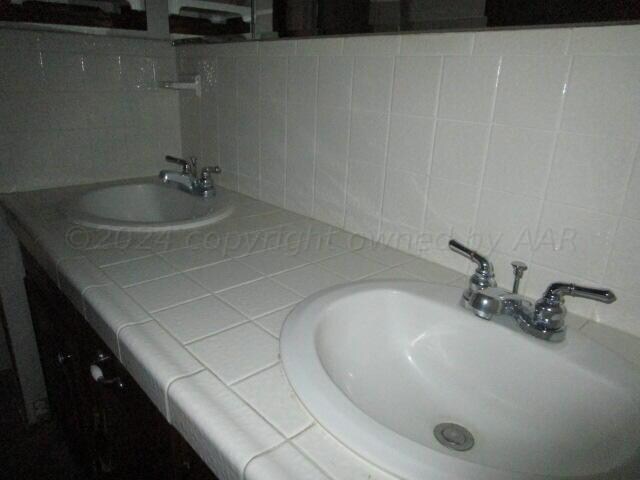 bathroom with decorative backsplash and vanity